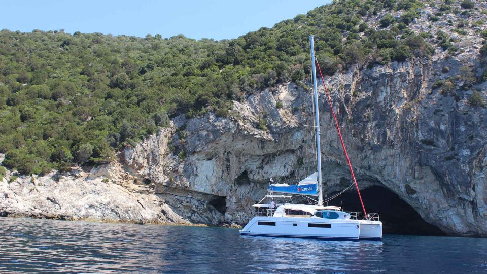 Sunsail catamaran anchoring next to Lefkas coast cave