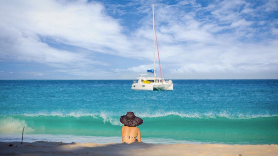 Woman watching yacht on seychelle sea
